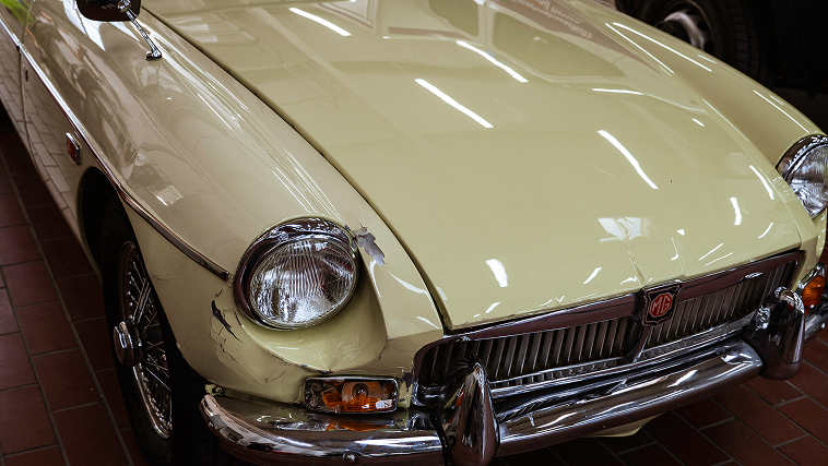Beschädigter cremefarbener MG Oldtimer vor Reparatur in NeuAnspach