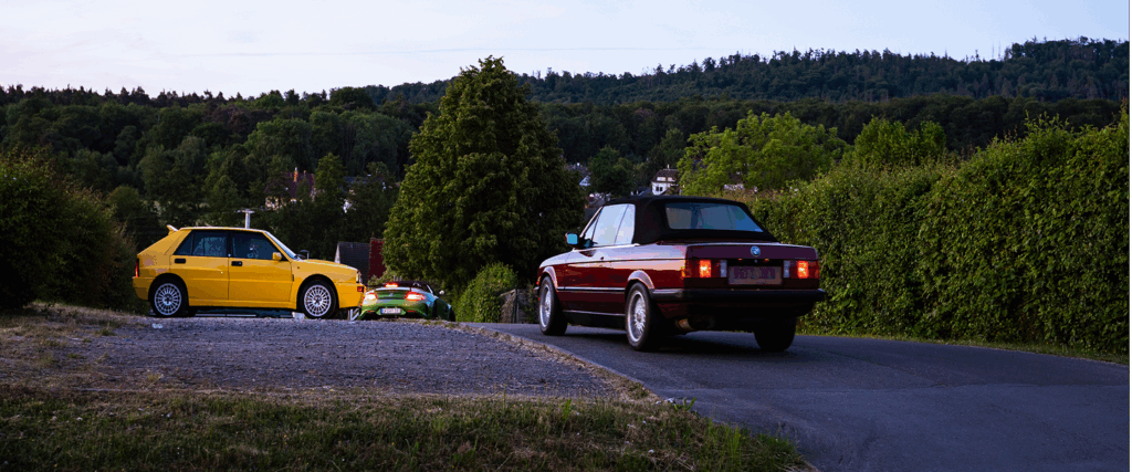 Drei klassische Fahrzeuge fahren auf Landstraße im Taunus